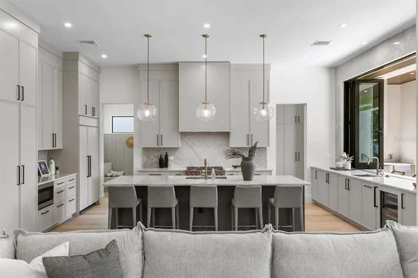 a kitchen with a refrigerator and white cabinets