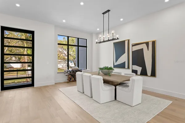 a large kitchen with granite countertop a stove a sink a center island a table and chairs