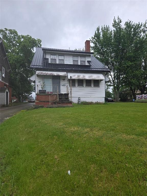 a view of a house with a big yard and large trees