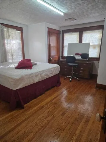 a bedroom with a bed and wooden floor