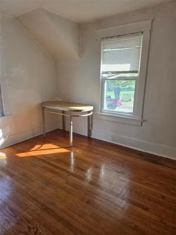 a view of room with window and wooden floor