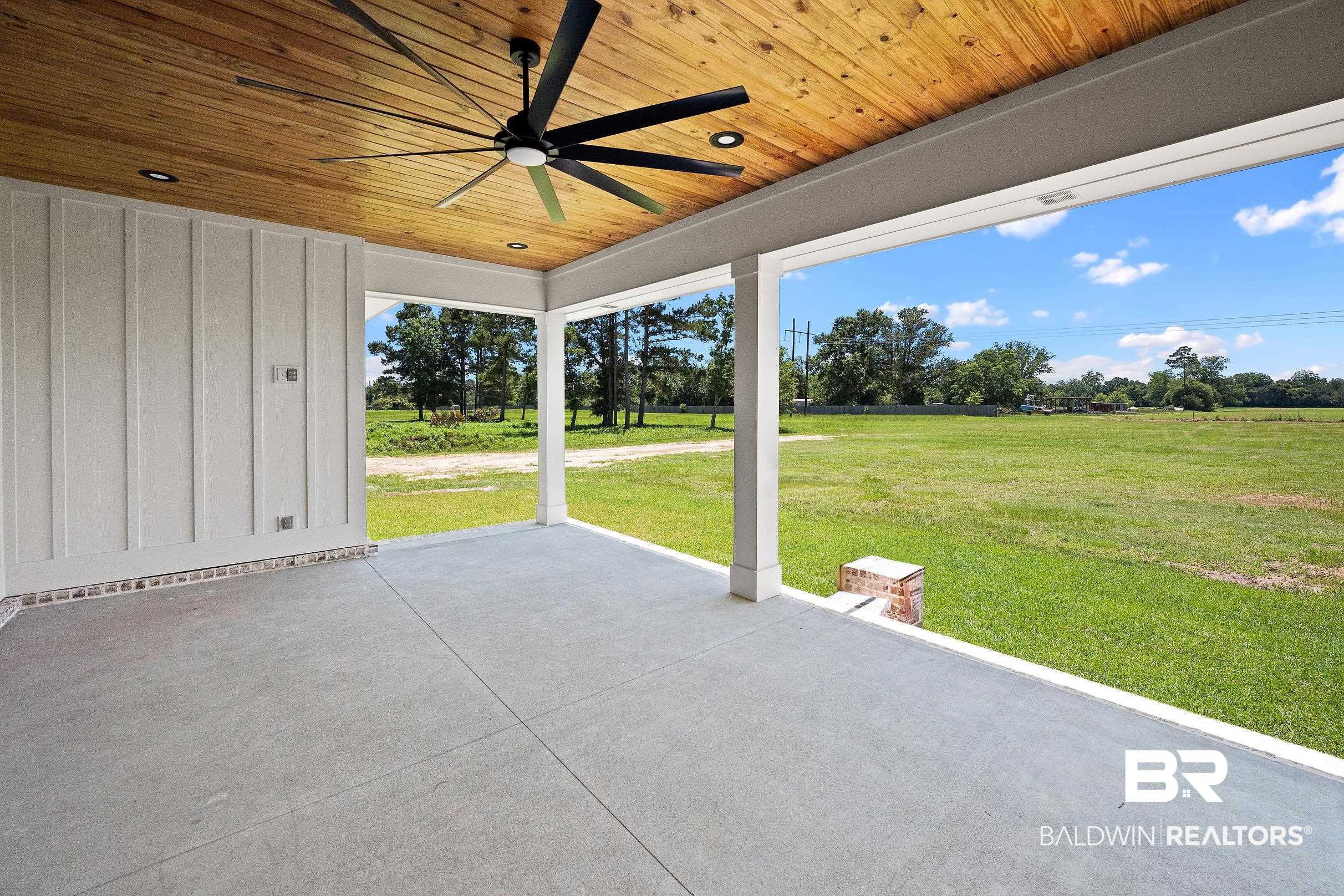 13111 Gopher Court Elberta, AL 36530 - Photo 36 of 41 Expansive covered patio featuring a wood-finish ceiling, large black ceiling fan, recessed lighting, concrete flooring, and white board and batten siding