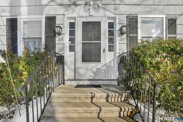 front view of a house with a large window and potted plants