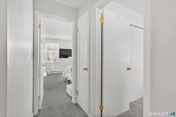 a walk in closet with wooden floor