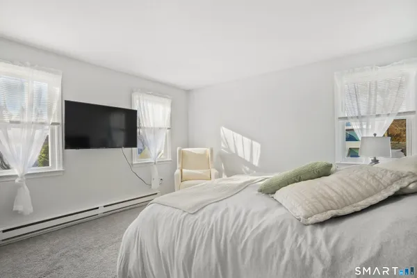 a bedroom with a bed tv and window