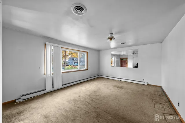 an empty room with windows and fan