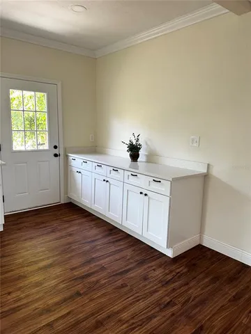 a view of a room with wooden floors and white walls