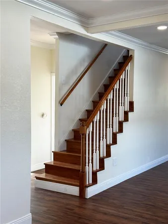 a view of staircase with wooden floor and white walls
