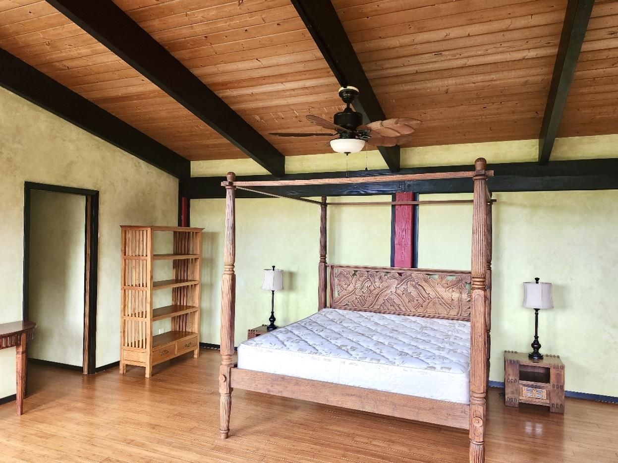 59 Door Of Faith Road Haiku, HI 96708 - Photo 14 of 45 a bedroom with a bed and a wooden floor