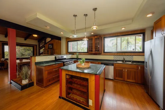 a kitchen with stainless steel appliances granite countertop wooden floors stove and sink