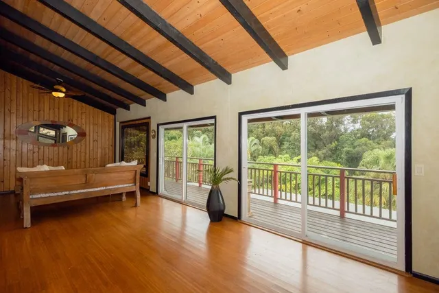 a kitchen with stainless steel appliances kitchen island granite countertop wooden floors and a view of living room