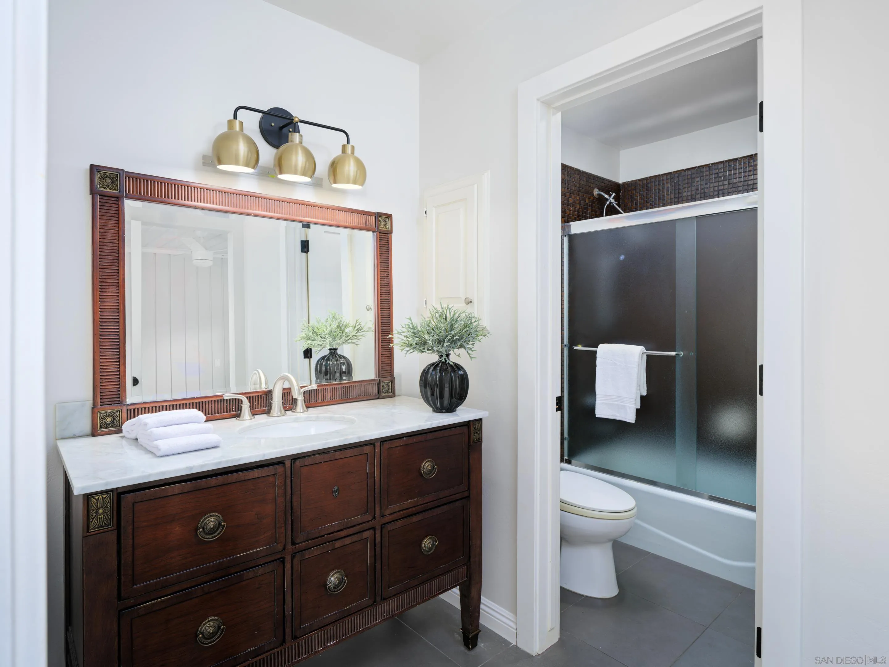 3520 Silvergate Place San Diego, CA 92106 - Photo 25 of 35 a bathroom with a toilet sink and mirror