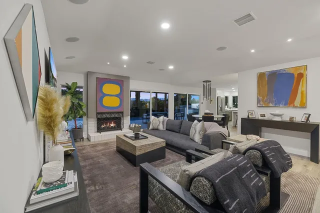 a living room with fireplace furniture and a large window
