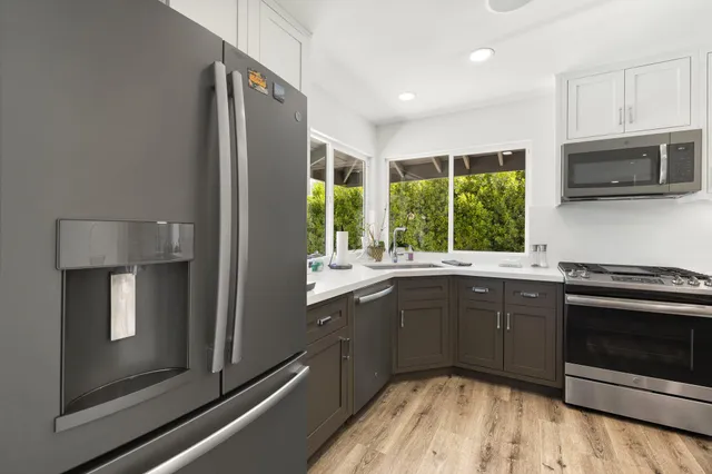 a kitchen with stainless steel appliances granite countertop a stove a sink and a microwave