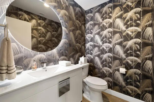 a bathroom with a sink and mirror with toilet