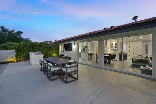 a roof deck with table and chairs a barbeque