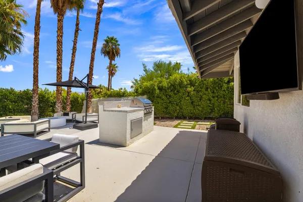 a view of a patio with table and chairs potted plants