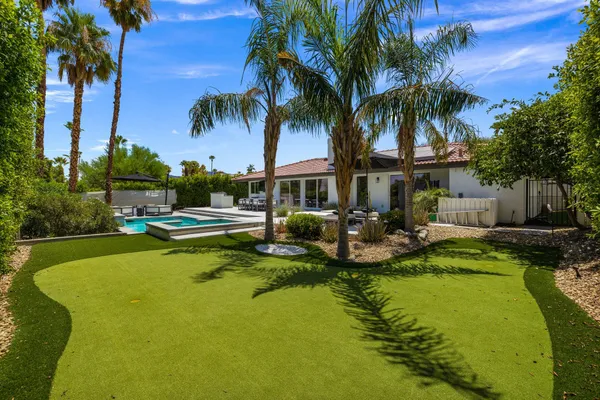 a view of swimming pool with outdoor seating and a garden