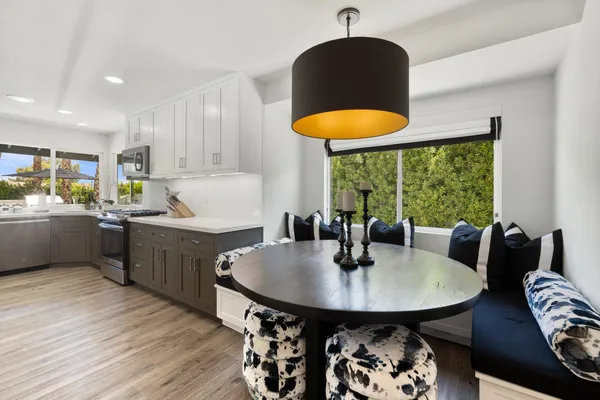 a kitchen with a table chairs sink and cabinets