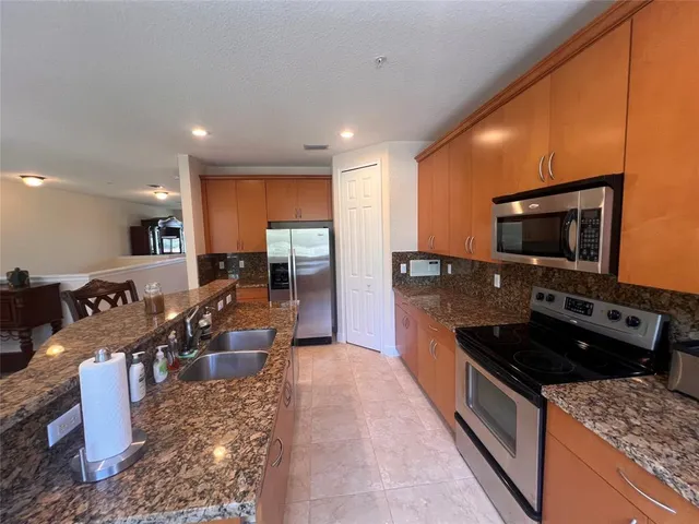 a large kitchen with stainless steel appliances granite countertop a stove and a sink