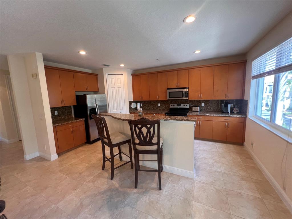 3014 Waterside Circle Boynton Beach, FL 33435 - Photo 30 of 40 a kitchen with granite countertop a refrigerator and a stove top oven