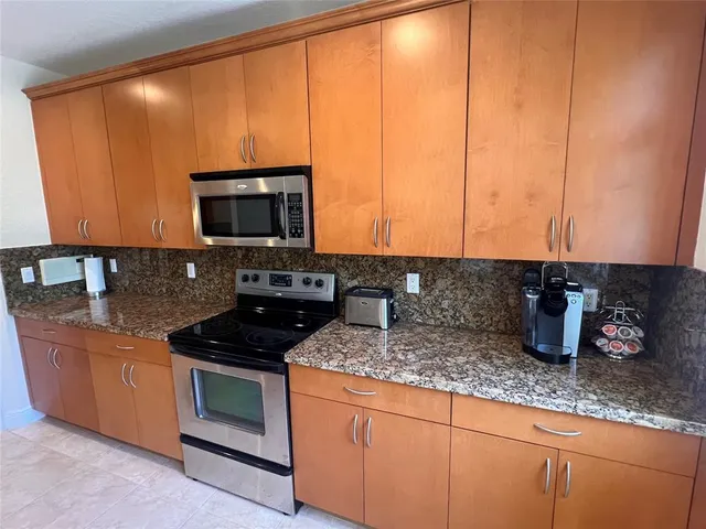 a kitchen with granite countertop a sink and a stove top oven