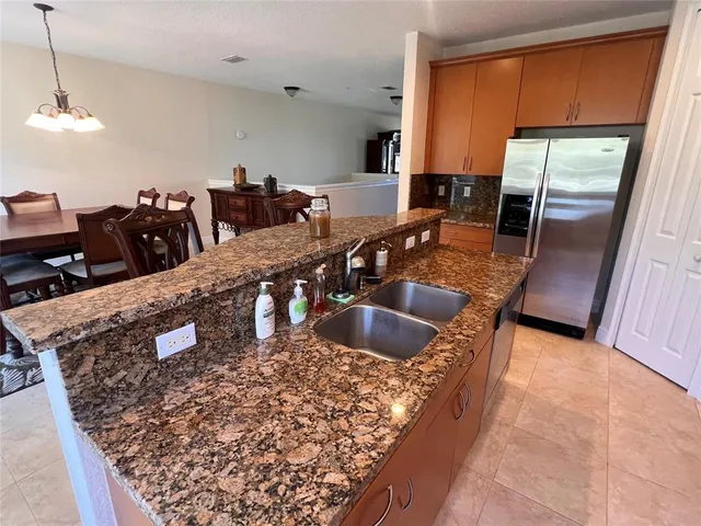 a kitchen with stainless steel appliances granite countertop a sink a stove counter space and blue cabinets