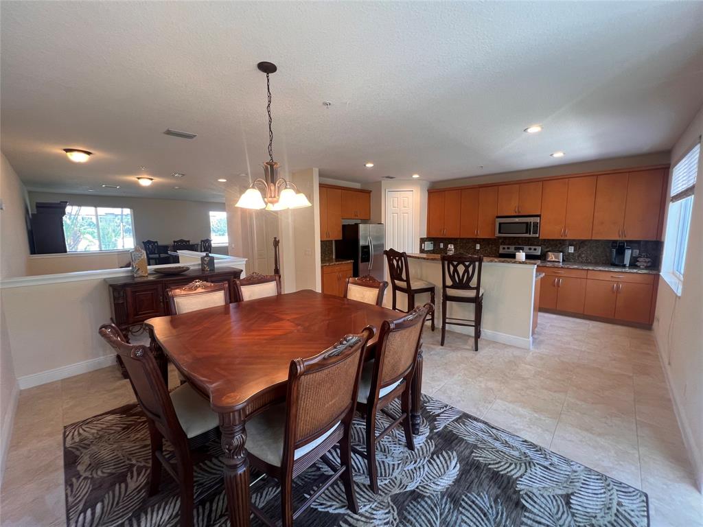 3014 Waterside Circle Boynton Beach, FL 33435 - Photo 5 of 40 a dining table with chairs a kitchen island a stove a table and chairs