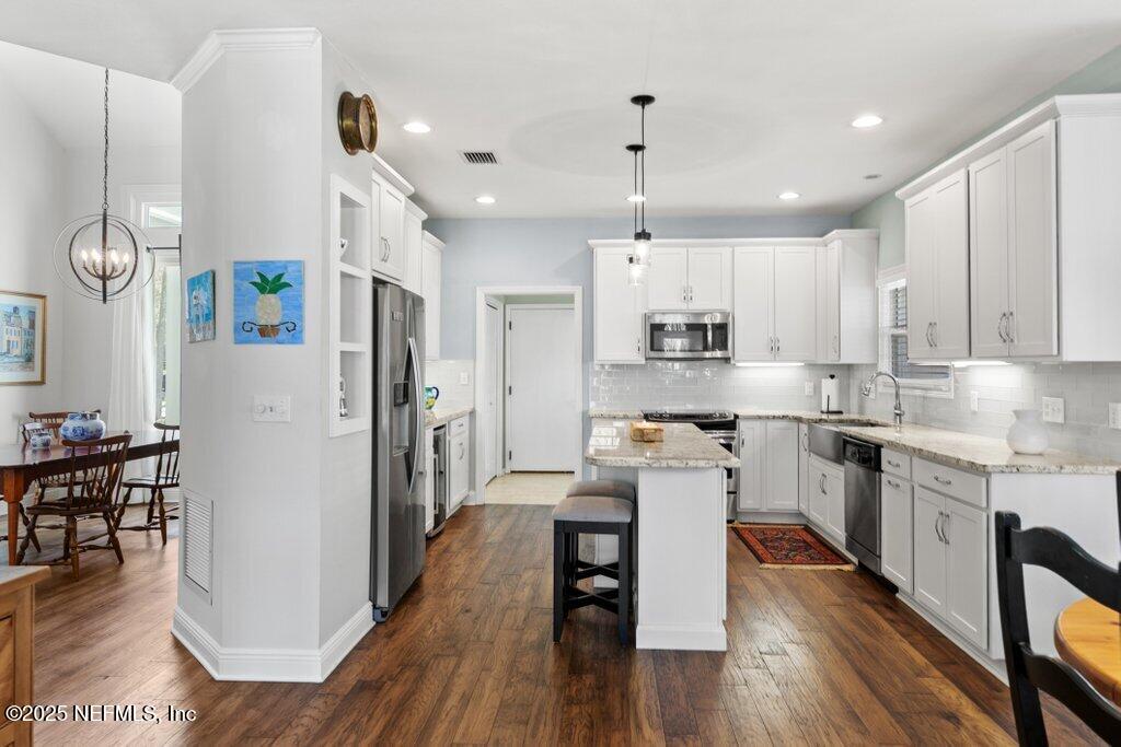 2307 Beachcomber Trail Atlantic Beach, FL 32233 - Photo 18 of 75 a kitchen with stainless steel appliances granite countertop a refrigerator a stove top oven a sink dishwasher and white cabinets with wooden floor