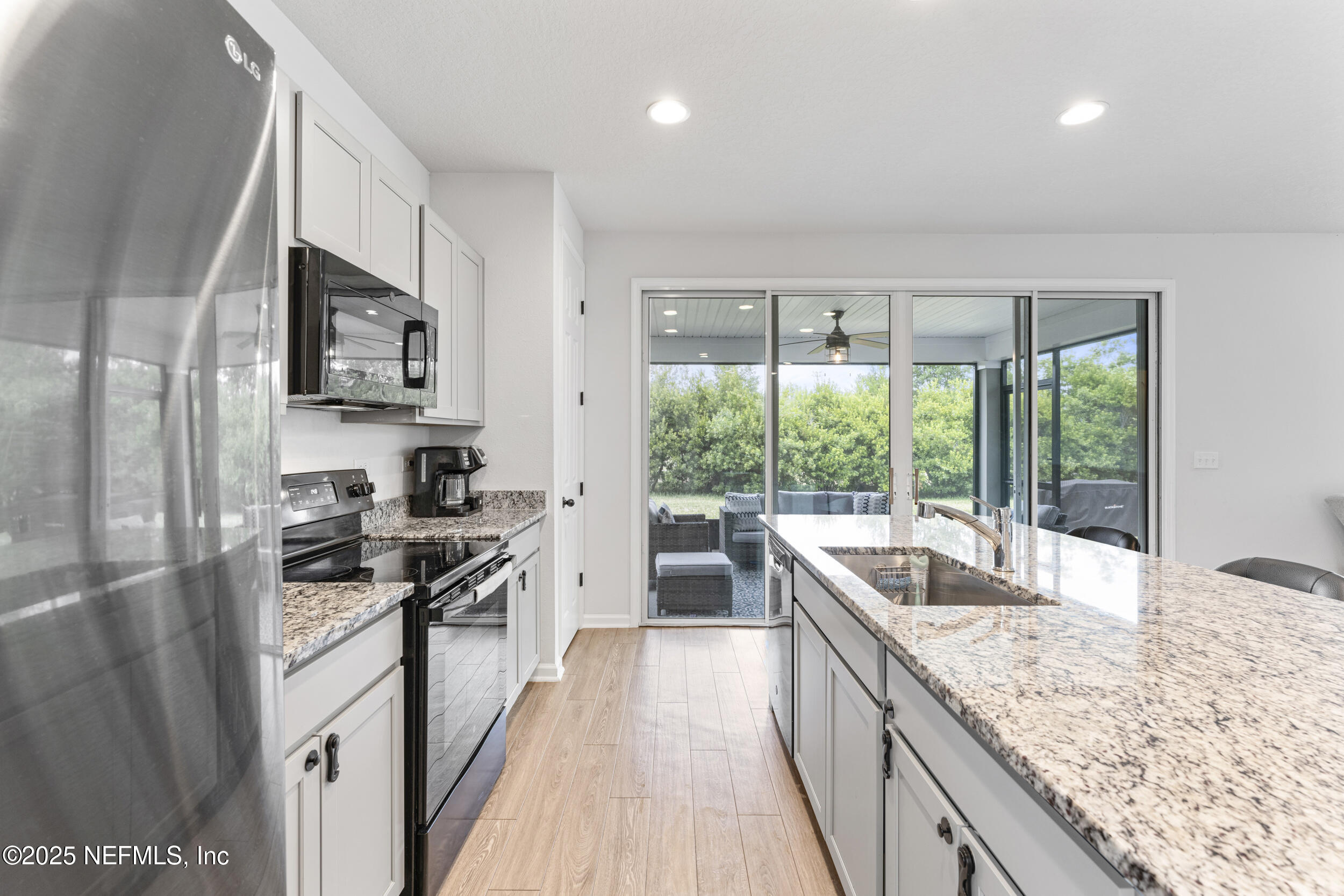 513 Sandstone Drive St. Augustine, FL 32086 - Photo 14 of 56 a kitchen with granite countertop a sink stove and refrigerator