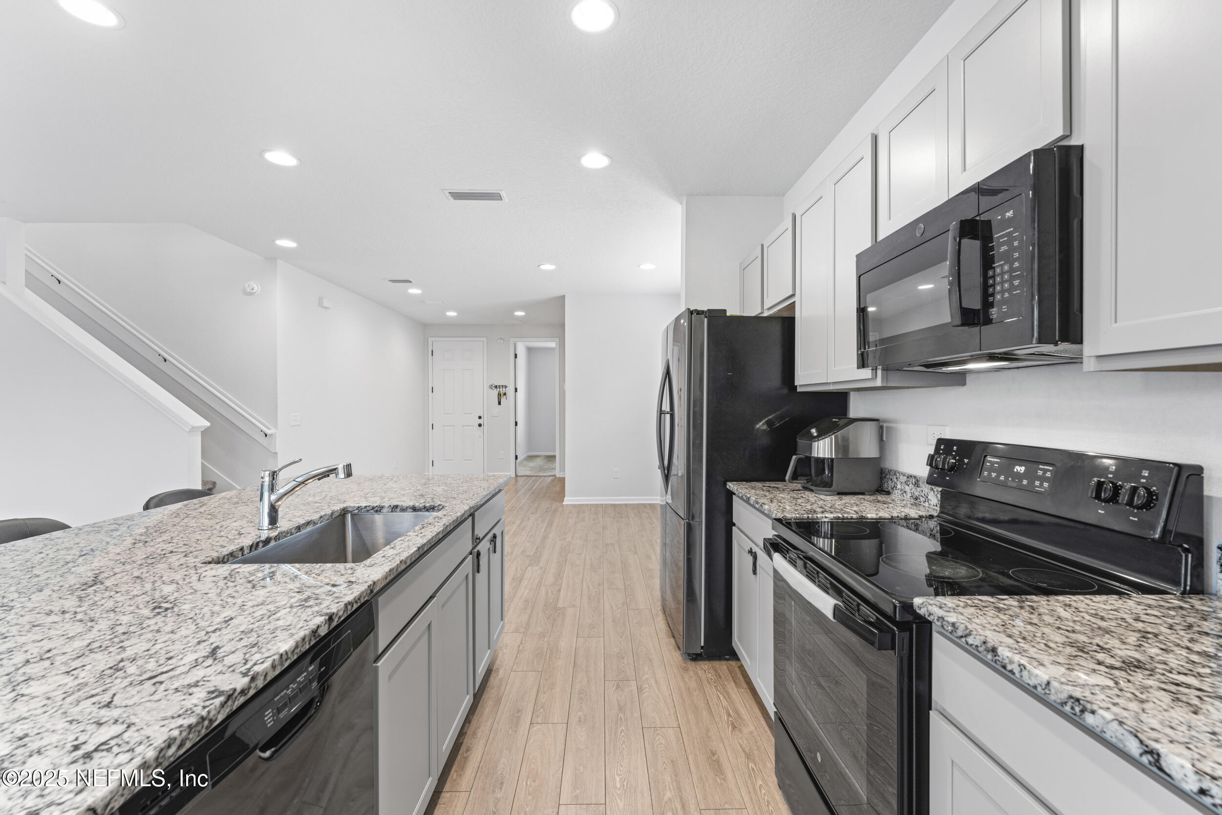 513 Sandstone Drive St. Augustine, FL 32086 - Photo 15 of 56 a kitchen with stainless steel appliances granite countertop a sink stove microwave and refrigerator