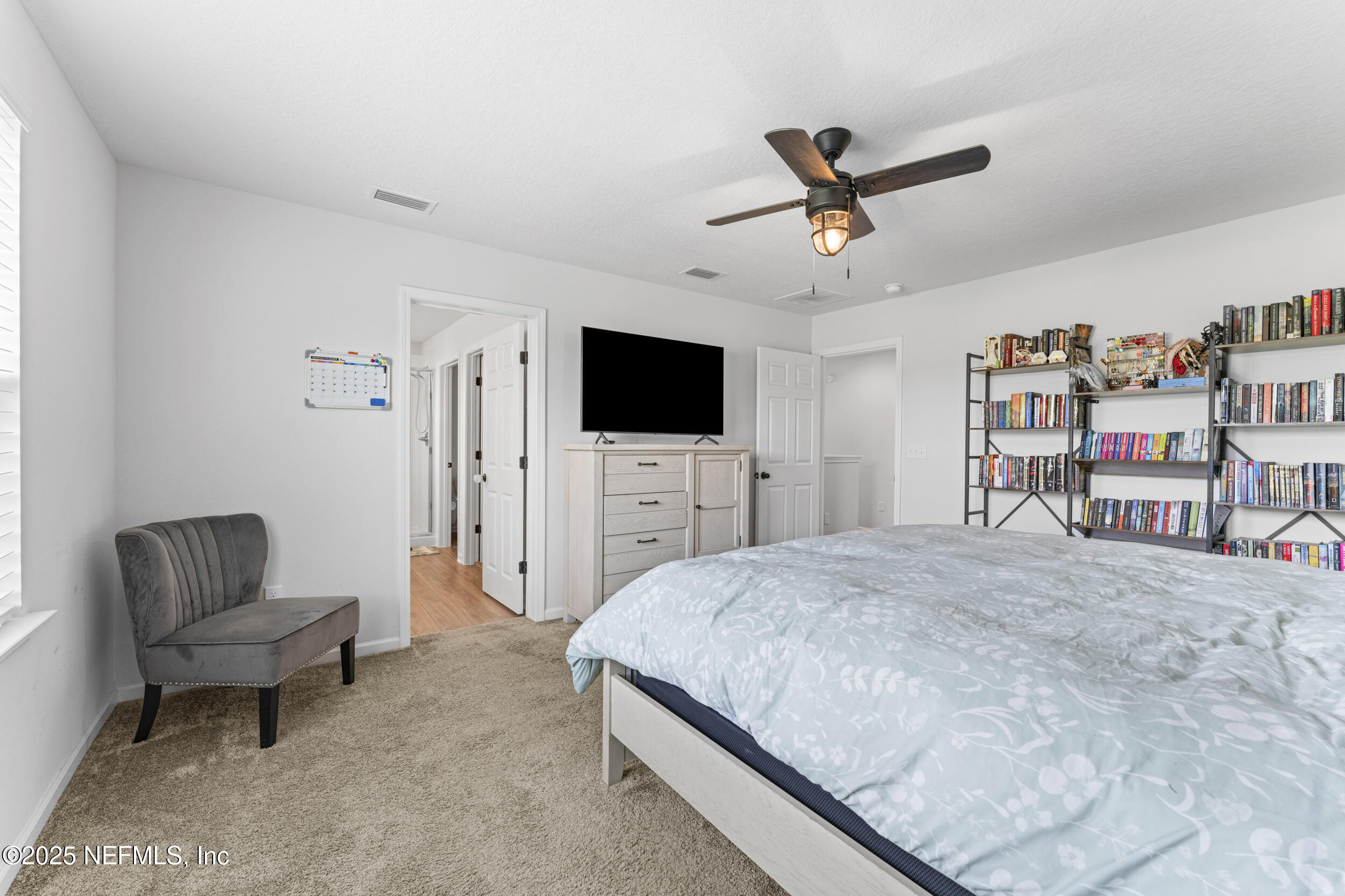 513 Sandstone Drive St. Augustine, FL 32086 - Photo 25 of 56 a spacious bedroom with a bed a flat screen tv and a couch