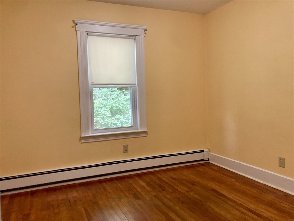 124 Bailey Road Holden, MA 01520 - Photo 23 of 37 a view of an empty room with wooden floor and a window