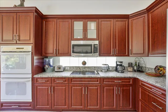 a kitchen with stainless steel appliances granite countertop a sink dishwasher stove and cabinets with wooden floor