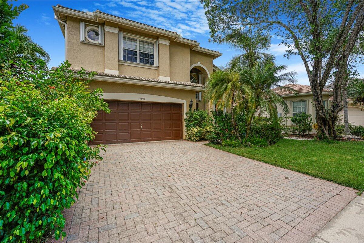 19059 Skyridge Circle Boca Raton, FL 33498 - Photo 8 of 40 a front view of a house with a yard and trees