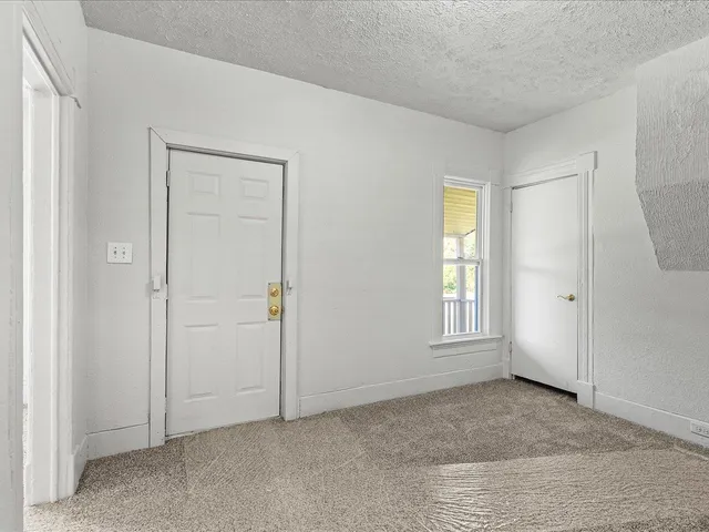 an empty room with way to room and entrance