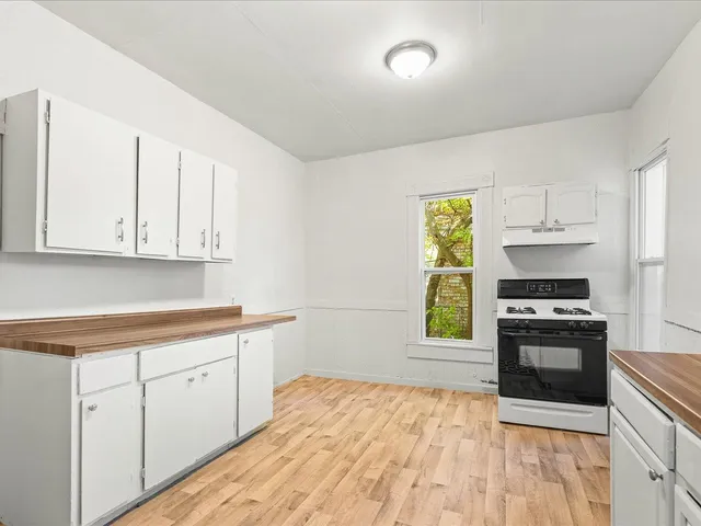 a kitchen with granite countertop a stove a sink and a refrigerator