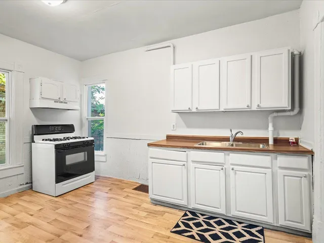 a kitchen with granite countertop a sink stove and cabinets