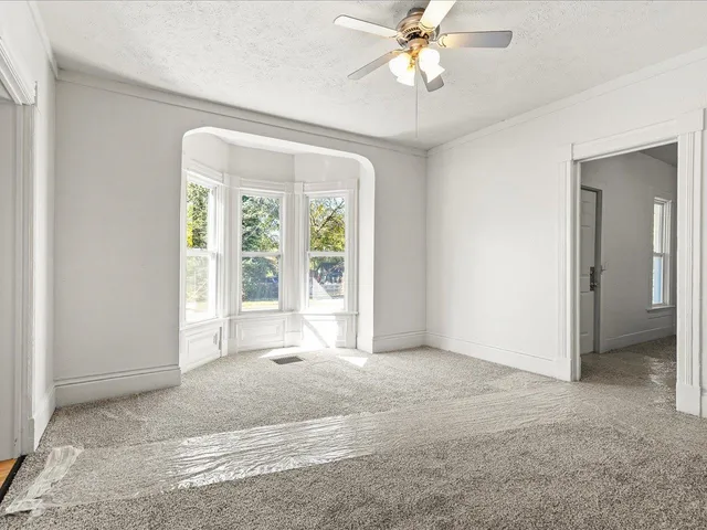an empty room with closet and a chandelier fan