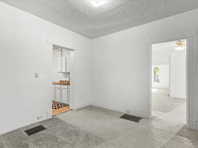 an empty room with way to room and entrance