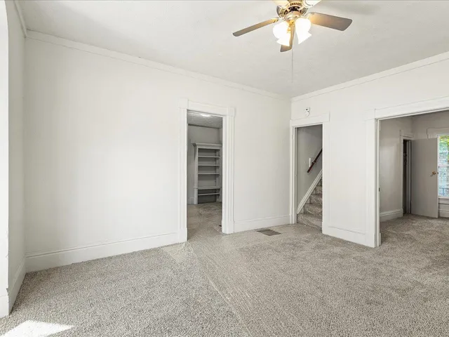 an empty room with closet and a chandelier fan