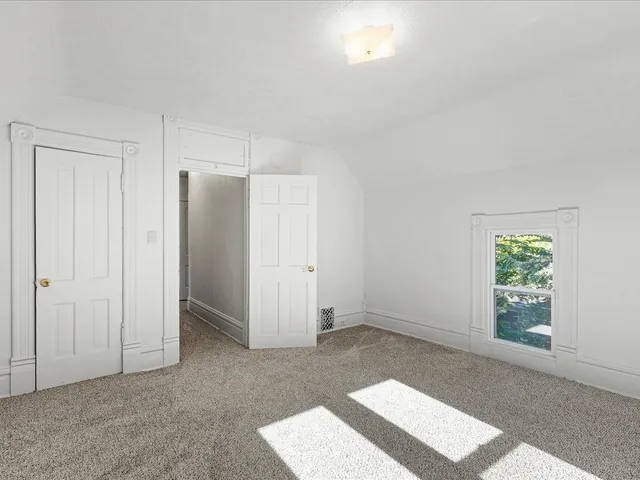 an empty room with windows and closet