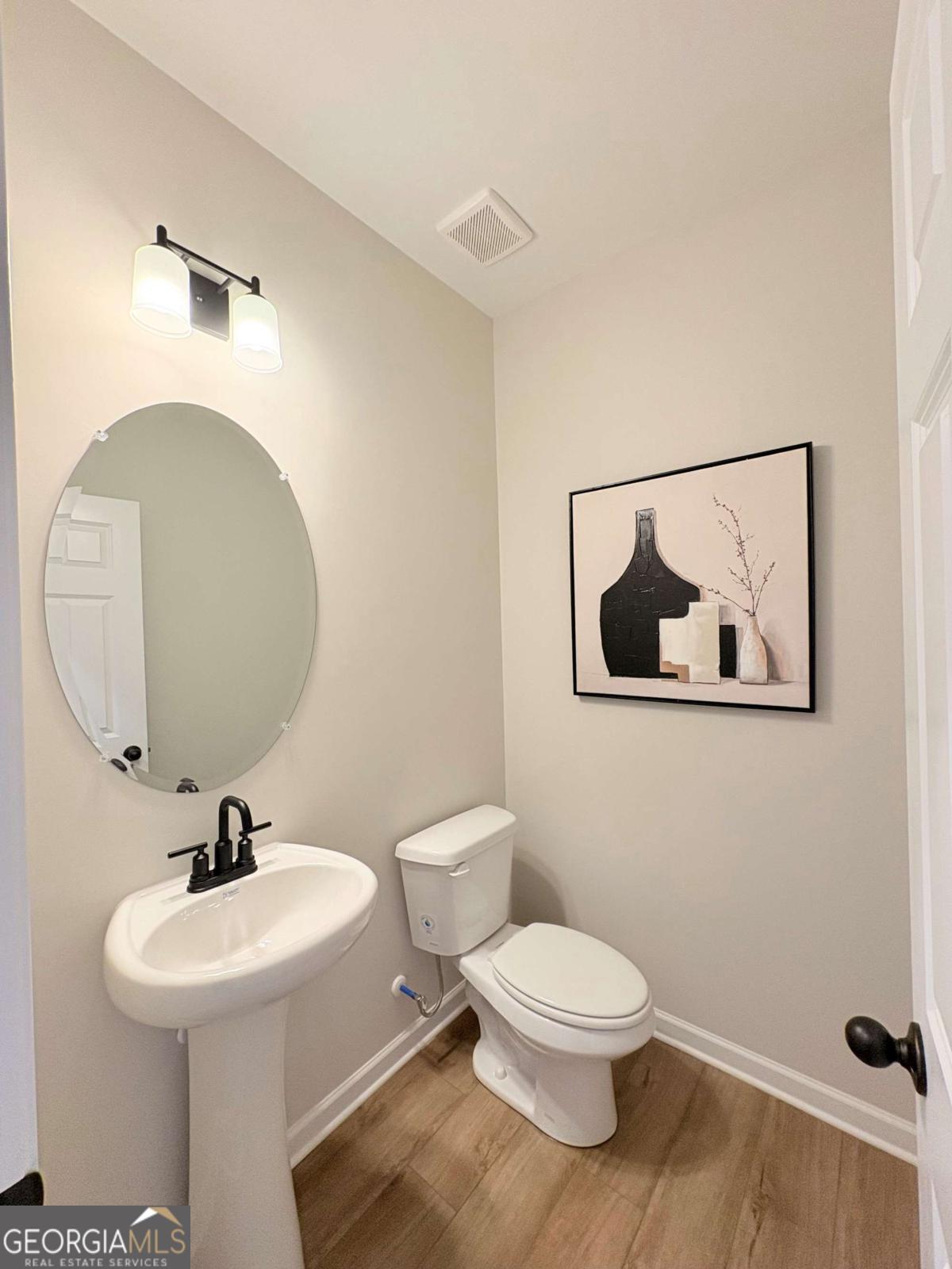 6155 Molo Lane Cumming, GA 30041 - Photo 15 of 29 a bathroom with a toilet a sink and mirror