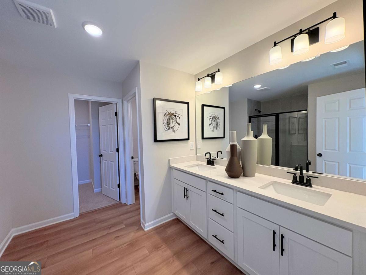 6155 Molo Lane Cumming, GA 30041 - Photo 21 of 29 a bathroom with a double vanity sink and a mirror