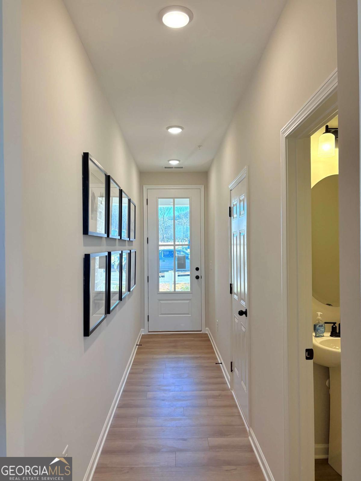 6155 Molo Lane Cumming, GA 30041 - Photo 3 of 29 a view of a hallway with wooden floor and windows