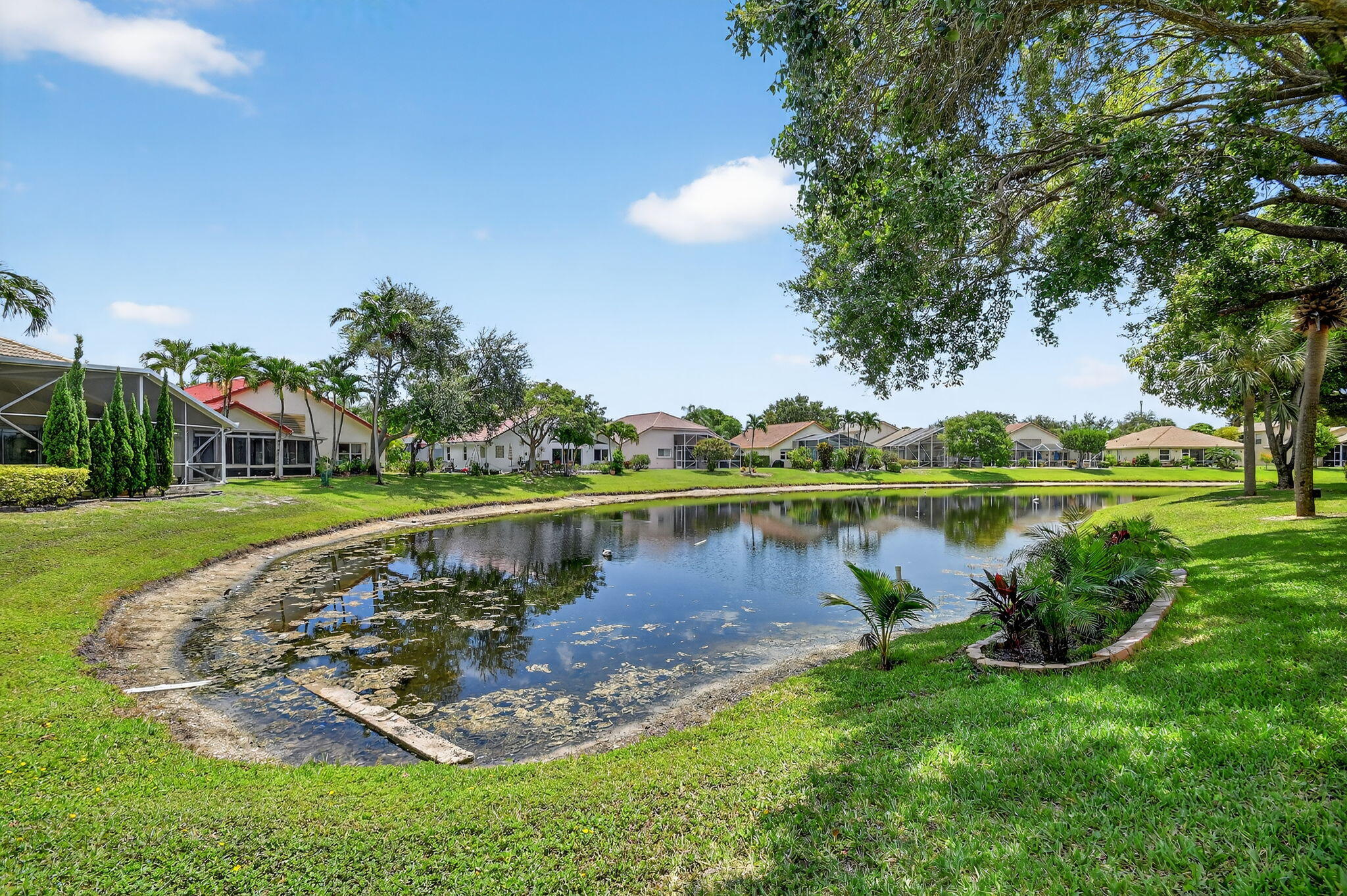 2804 Waters Edge Circle Greenacres, FL 33413 - Photo 51 of 74 a view of a lake with a house in the background