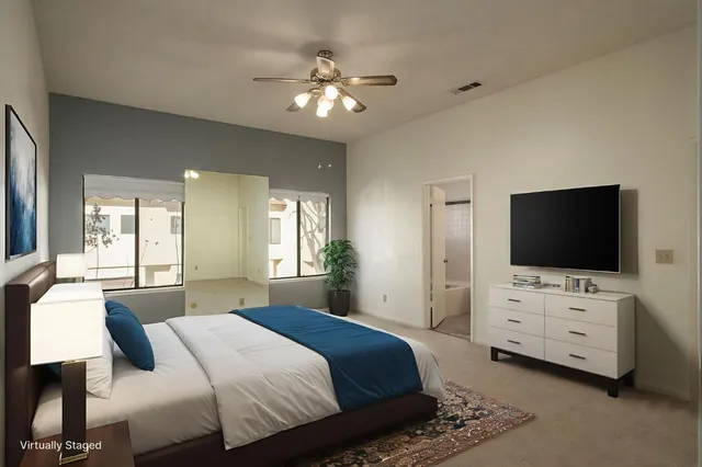 a bedroom with bed tv and view of bathroom