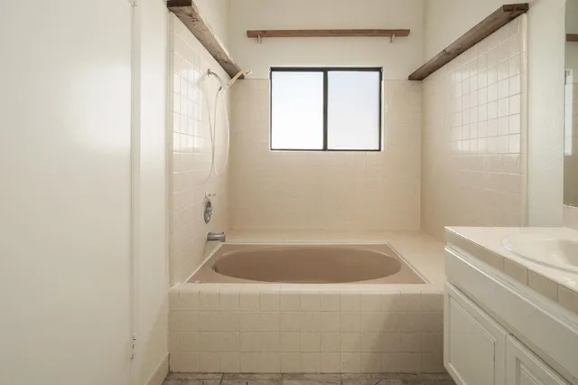 a white bath tub sitting next to a white sink