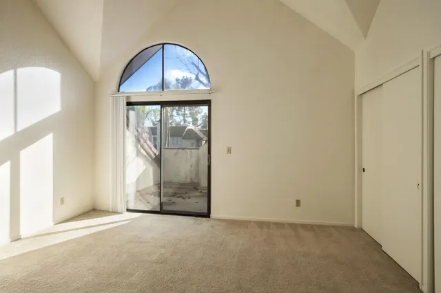 an empty room with wooden door and windows