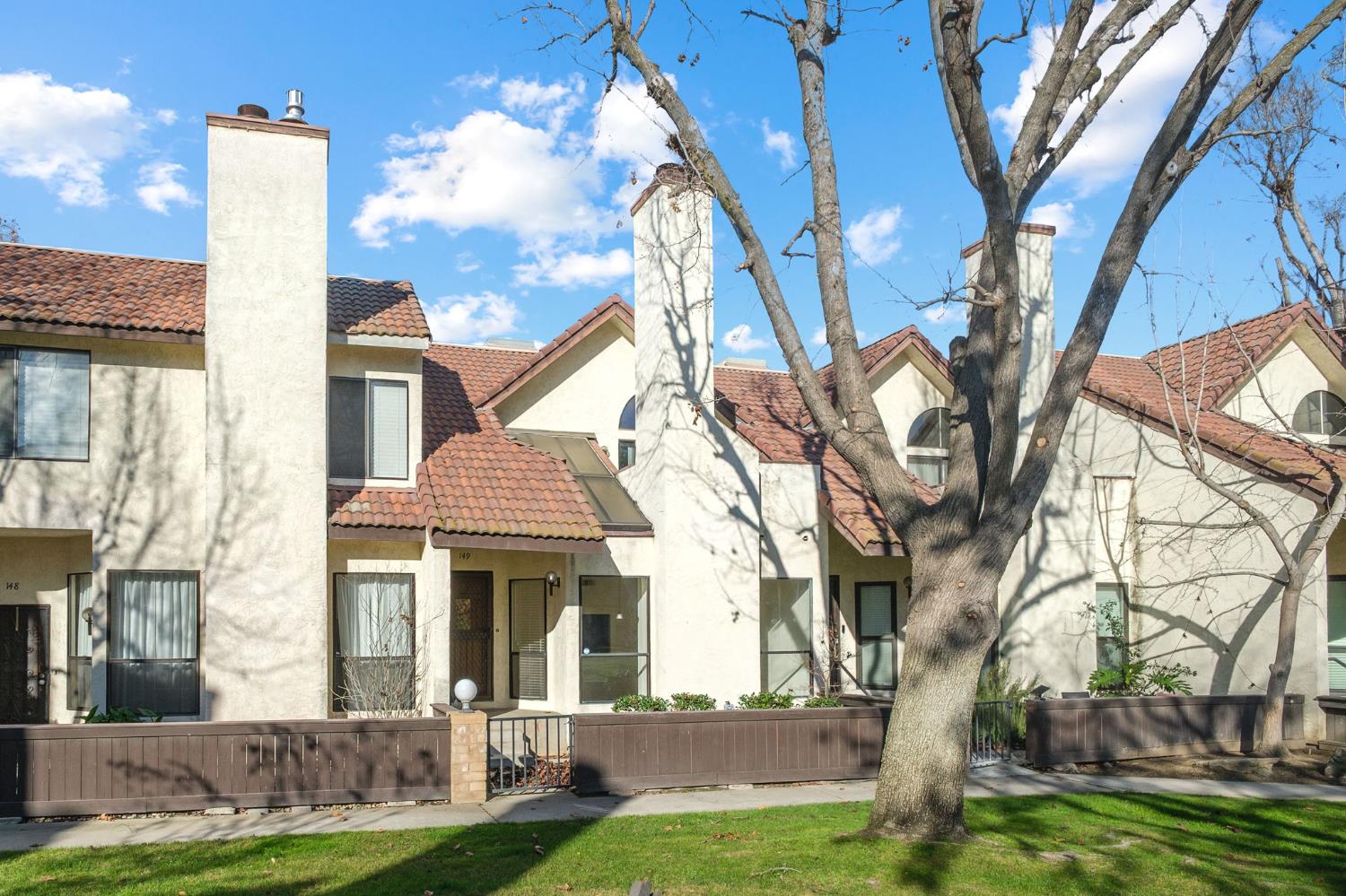 2890 Huntington Boulevard, Unit 149 Fresno, CA 93721 - Photo 2 of 30 a front view of a house with a yard